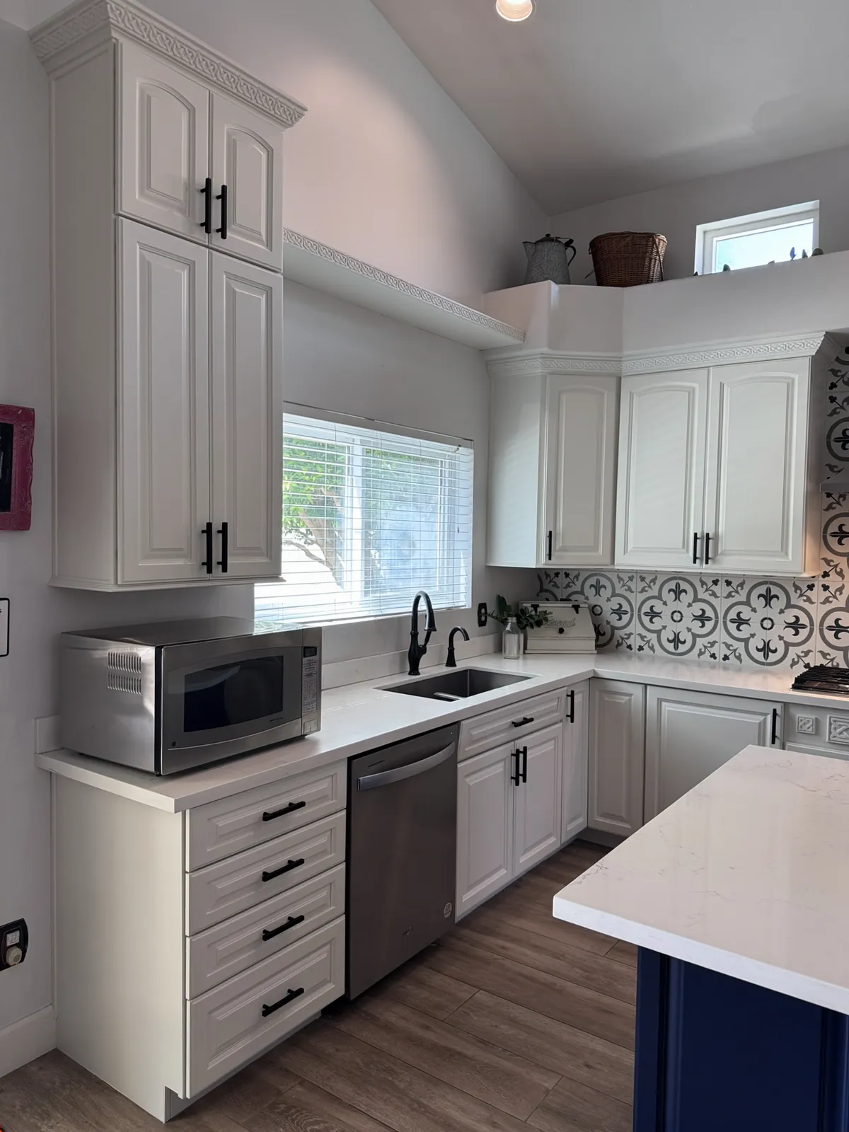 The same kitchen after Valley Painting Pros refinished the cabinets bright white.
