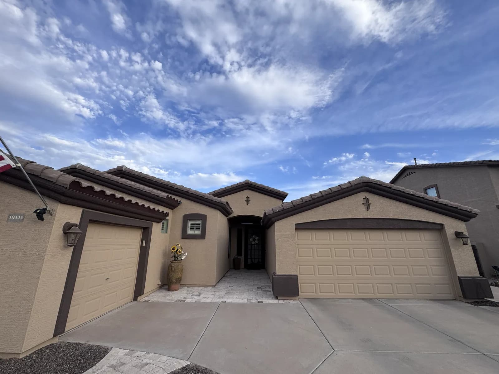 A newly painted tan stucco home under a wide blue Arizona sky — exterior repaint by Valley Painting Pros.