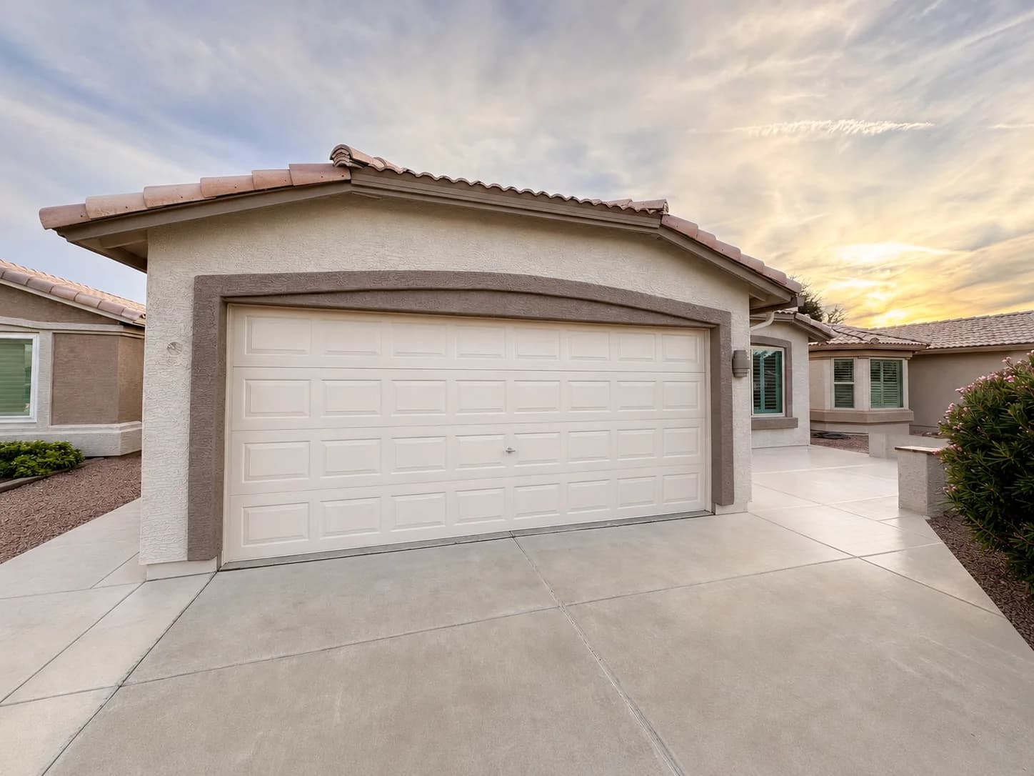 A freshly repainted single-story home and two-car garage at sunset — exterior work by Valley Painting Pros.