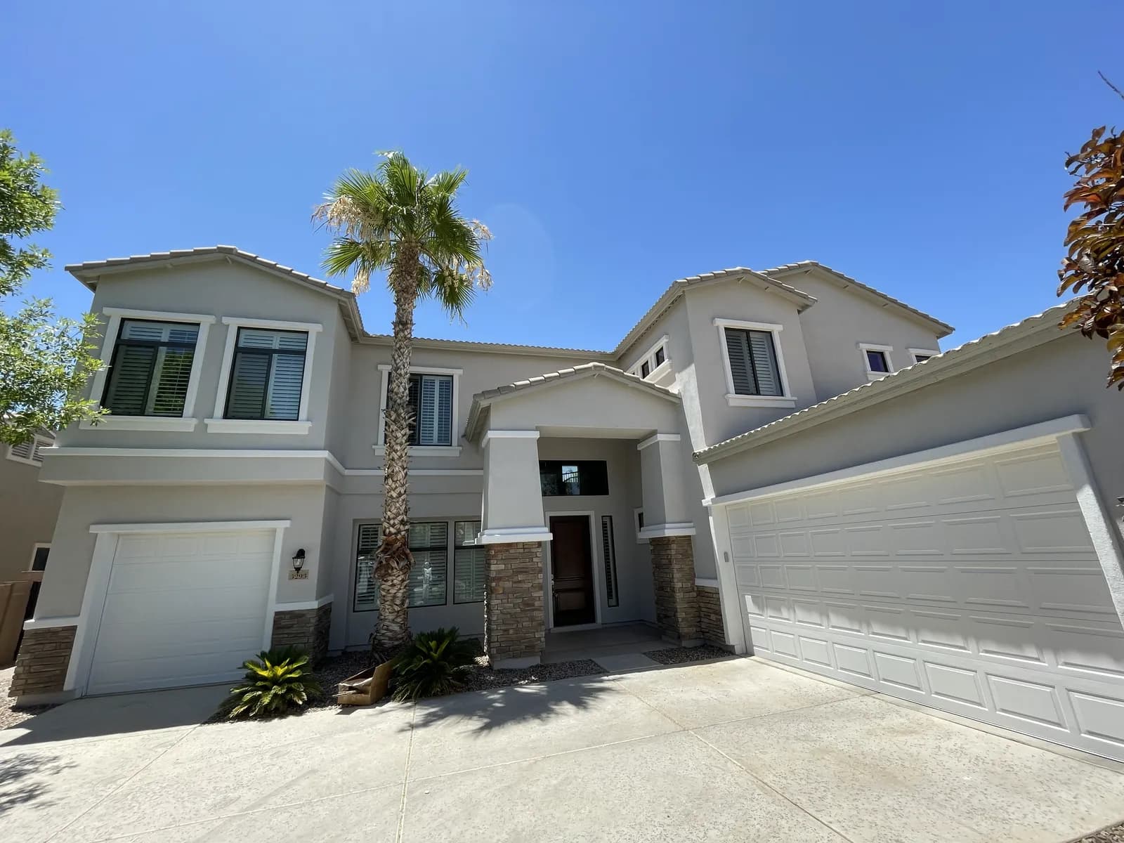 A large two-story greige home with a fresh exterior repaint by Valley Painting Pros.