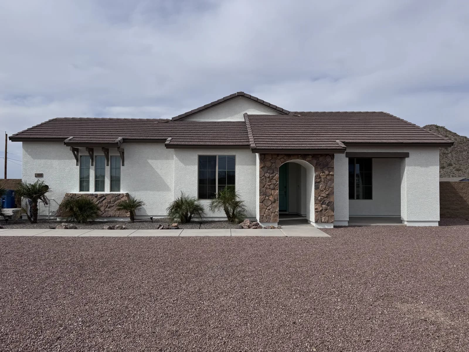 A single-story home with a stone entry arch, newly painted by Valley Painting Pros.