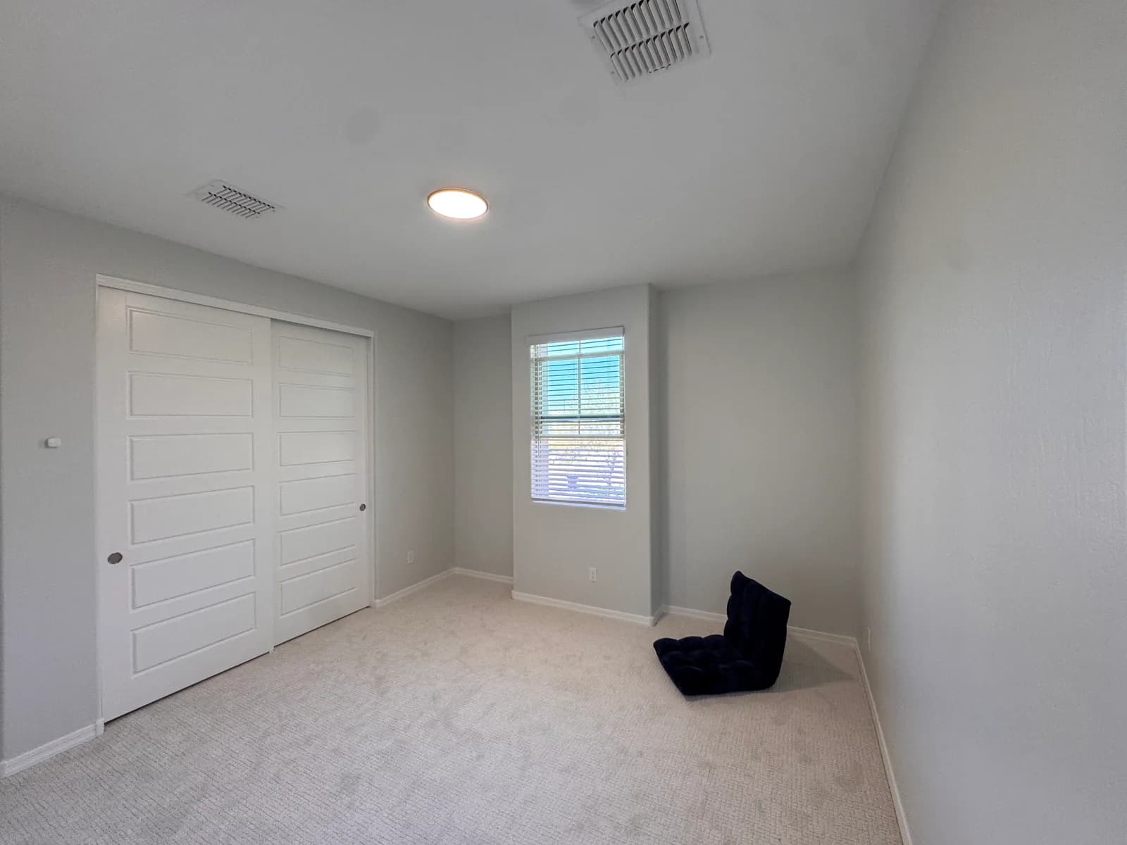 A bedroom repainted in soft gray with crisp white sliding closet doors and trim — Valley Painting Pros.