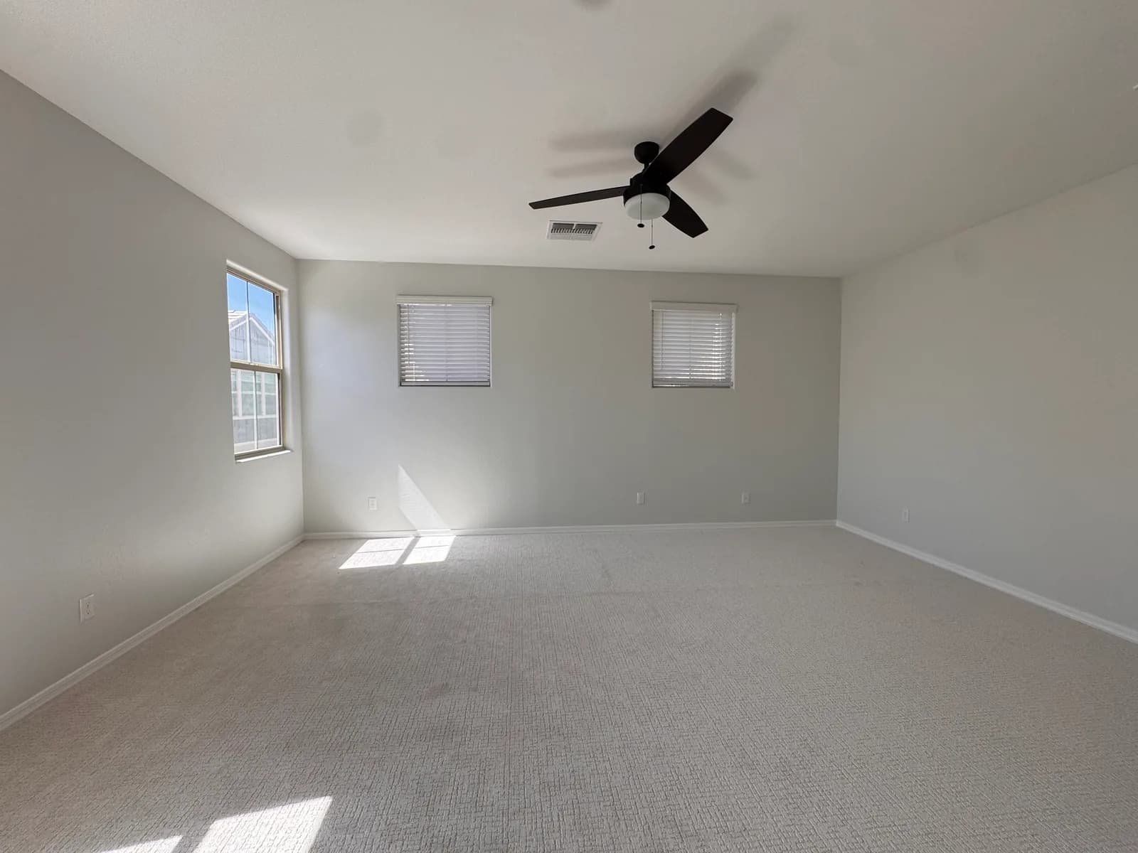 A spacious master bedroom freshly repainted in soft gray with clean white ceilings and trim — Valley Painting Pros.