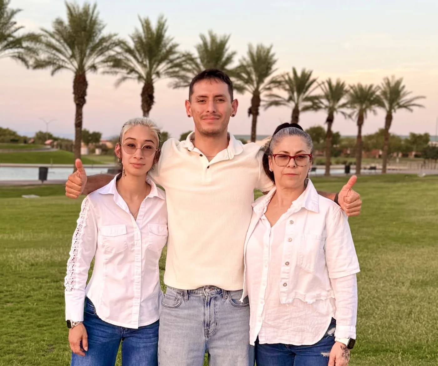 Gereimy, Ricardo Parra and his mom Luz, standing together in a park at sunset.