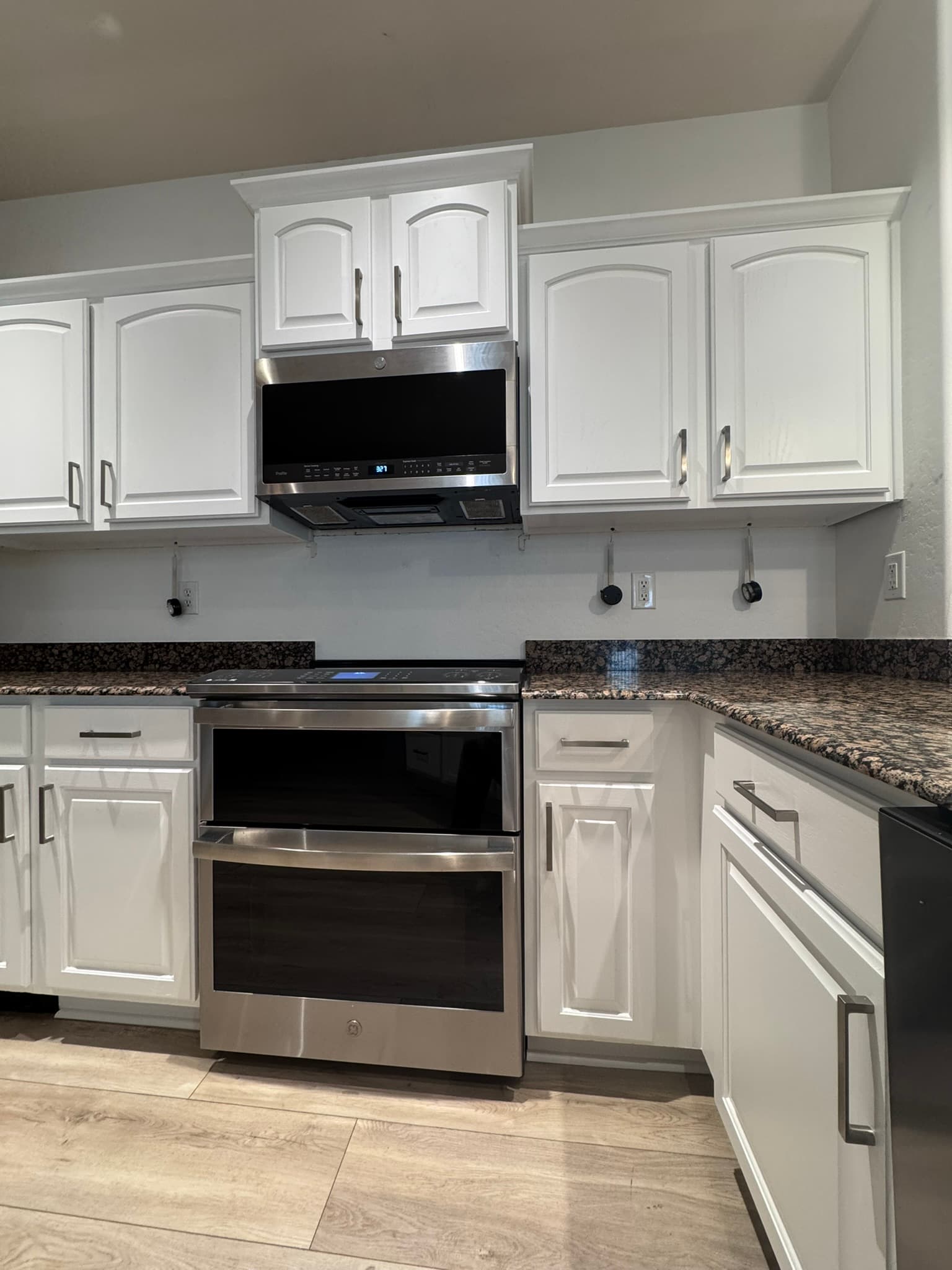 Refinished white kitchen cabinets around stainless range